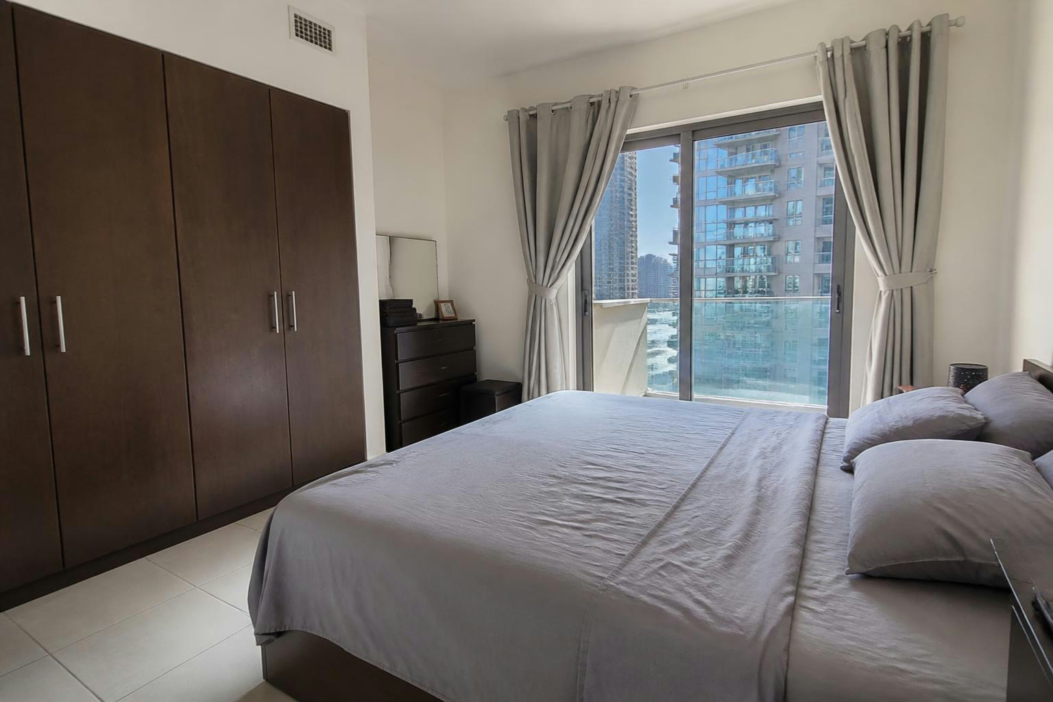 Hálószoba egy Dubai Marina-i lakásban, erkélyajtóval